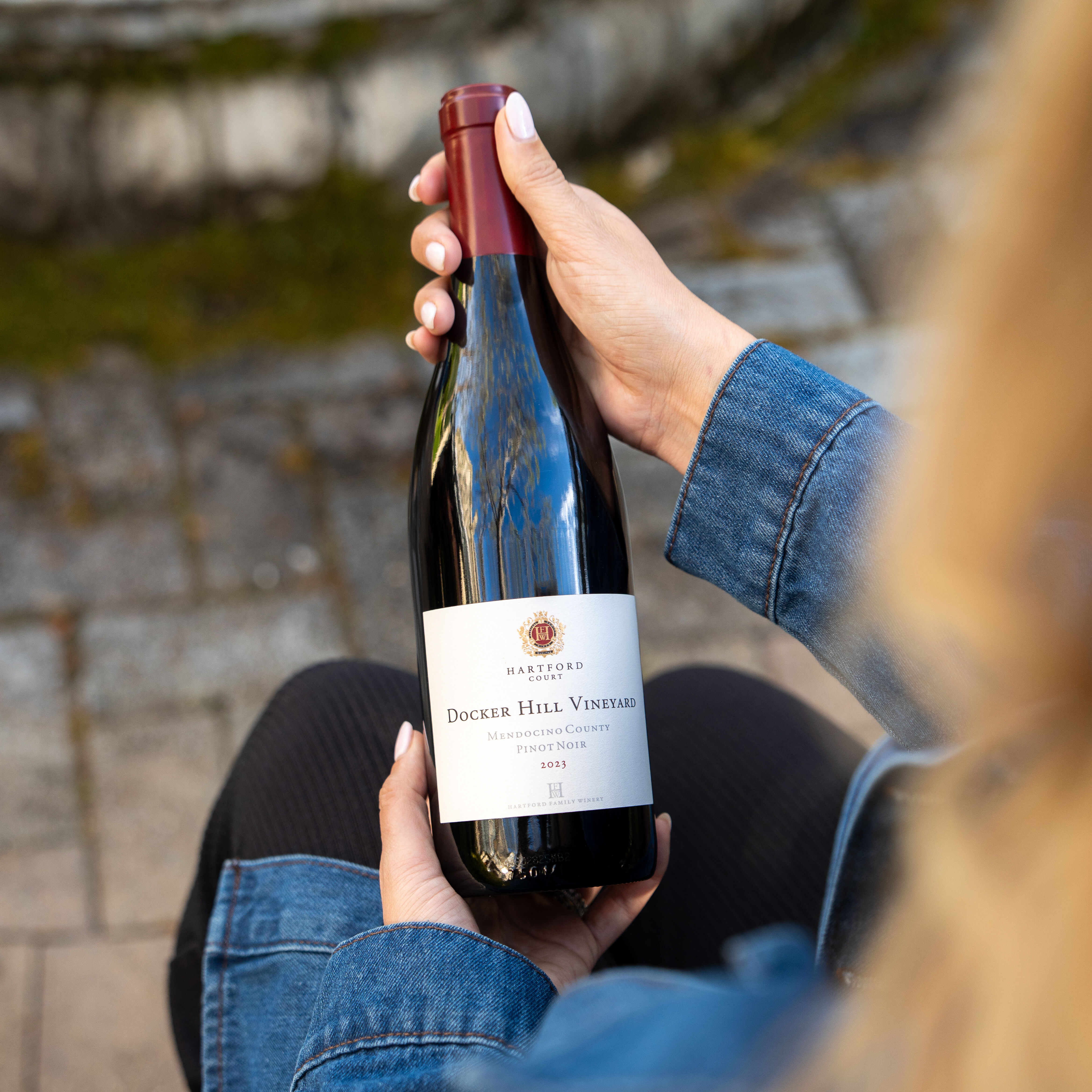 A person holding a bottle of Docker Hill Vineyard Pinot Noir